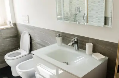 a white bathroom with a toilet and a sink at Casa Santarelli in Rome