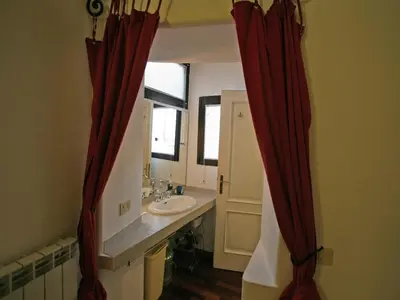 a bathroom with red curtains and a sink at Casa Leopardo - Trastevere in Rome