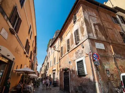 a group of people walking down a narrow street at Residenza Paola - 2BR Trastevere in Rome