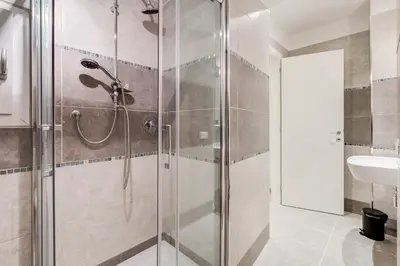 a shower with a glass door in a bathroom at Vaticano 38 Suites in Rome
