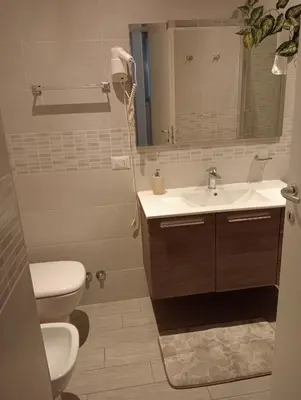 a bathroom with a sink and a toilet and a mirror at Holiday House Roma Vaticano in Rome