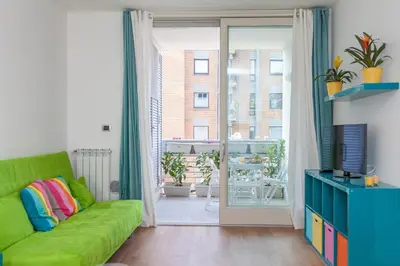 a living room with a green couch and a sliding glass door at Boutique Domus in Rome
