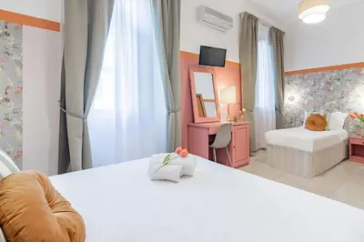a bedroom with a white bed with a mirror and a room with a bedskirts at Hotel Espana - Gruppo BLAM HOTELS in Rome