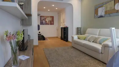 a living room with a white couch and a vase of flowers at Your Home at Rome in Rome