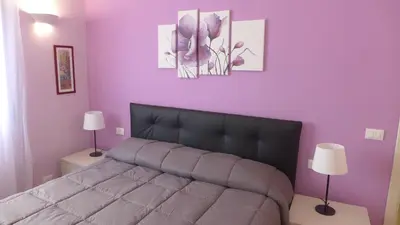 a bedroom with a bed and a purple wall at Your Home at Rome in Rome