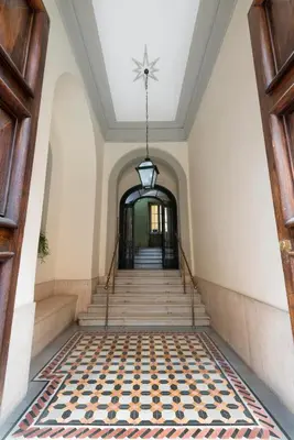 a hallway with stairs and a chandelier at Vaticanspace Rooms in Rome