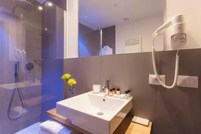 a bathroom with a white sink and a shower at Giuturna Boutique Hotel in Rome