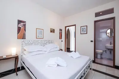 a white bedroom with a bed and a sink at Monteverde 2BDR Family Apartment in Rome