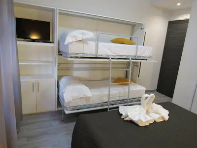 a room with three bunk beds and a table at Pianeta Roma 127 in Rome