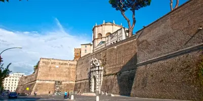 a large brick wall with a building in the background at Pianeta Roma 127 in Rome