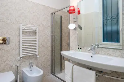 a bathroom with a sink and a mirror and a toilet at Prime Vatican Suites in Rome