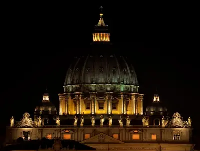 a large building with a dome at night at Prime Vatican Suites in Rome