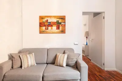 a living room with a couch and a painting on the wall at Living RHome - Condotti Apartment in Rome
