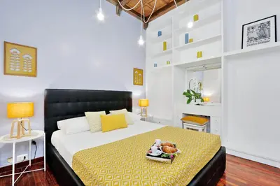 a bedroom with a large bed with a yellow blanket at Laterano 238 Apartment in Rome