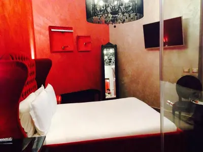 a bedroom with a bed and a red wall at iRooms Central Station in Rome