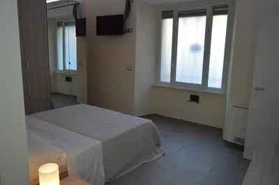 a bedroom with a white bed and two windows at Bea&B in Rome