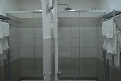 a shower with glass doors and towels in a bathroom at Bea&B in Rome