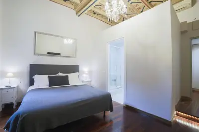 a bedroom with a bed and a chandelier at La Maison Dell'Orologio in Rome
