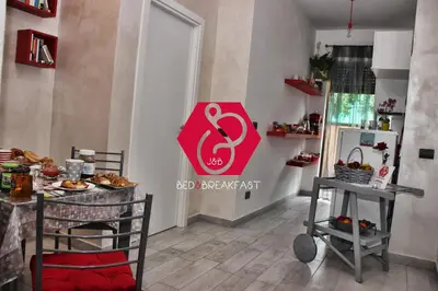 a kitchen with a table and a pink sign on the wall at B&B J&B in Rome