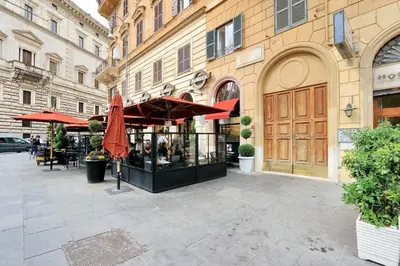 a cafe with red umbrellas on a city street at Parrotshouse in Rome