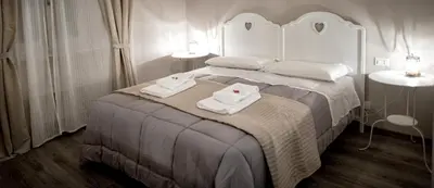 a white bedroom with two towels on a bed at TinkerBell GuestHouse in Rome
