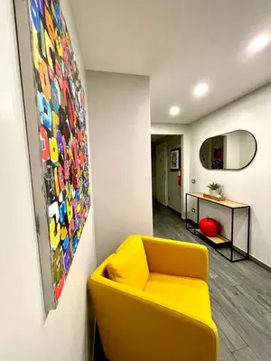 a living room with a yellow couch and a painting at Your House By Ale in Rome