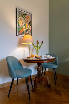 a table with two chairs and a lamp in a room at B&B A Casa di Tiziana - Roma in Rome