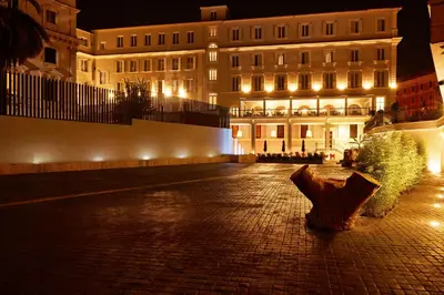 a building at night with an umbrella in front of it at Hotel The Building in Rome