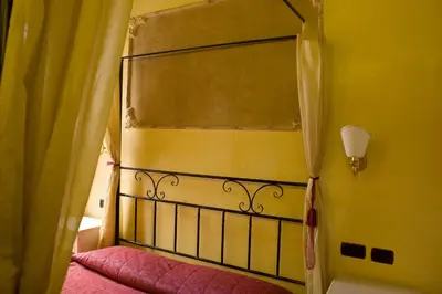 a bedroom with a bed and a yellow wall at Sweet Dream Trevi in Rome