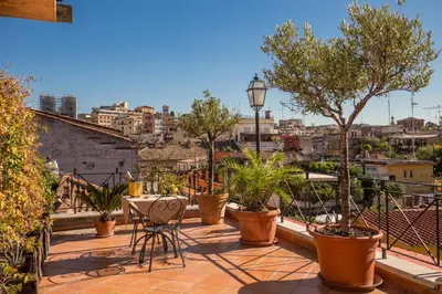 a balcony with a table and chairs and plants at Hotel La Lumiere Di Piazza Di Spagna in Rome