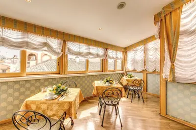 a restaurant with two tables and chairs and windows at Hotel La Lumiere Di Piazza Di Spagna in Rome