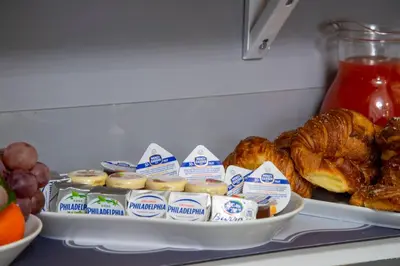 a refrigerator filled with bread and pastries and other foods at Lea Luxury Rooms in Rome