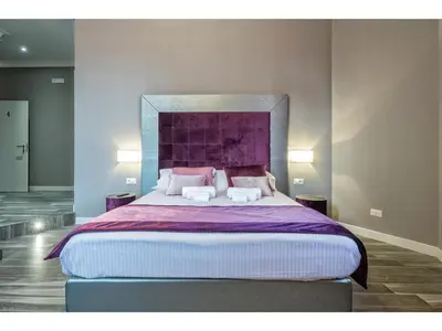 a bedroom with a large bed with two pillows at Lea Luxury Rooms in Rome