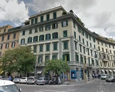 a large white building with cars parked in front of it at Bed And Breakfast King Plaza in Rome