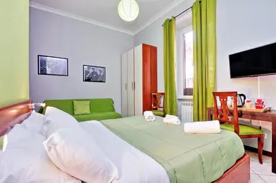 a bedroom with a bed and a desk and a television at Lucky Home rooms in Rome