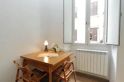 a table and two chairs in a room with windows at Lucky Home rooms in Rome