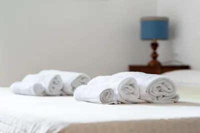 three towels are stacked on a bed at Monti Garden in Rome