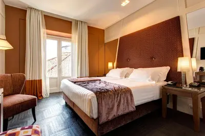 a hotel room with a bed and a chair at Mascagni Luxury Rooms & Suites in Rome
