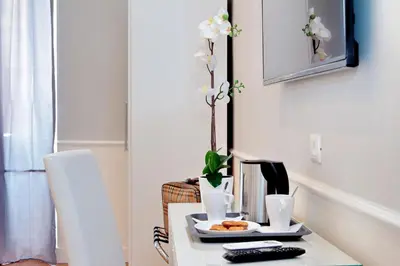 a white table with a plate of food on it at St. Peter Vatican Rooms in Rome