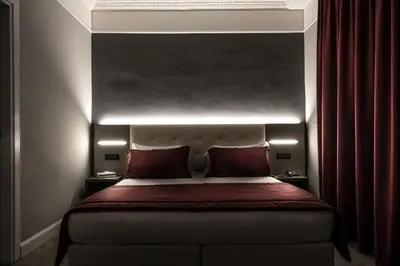 a bedroom with a large bed with red pillows at Hotel Varese in Rome