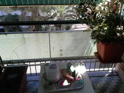 a balcony with a table with a cup and a candle at Olimpica Relais guest house in Rome