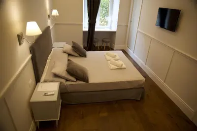 a small bed in a small room with a window at Relais della Torre in Rome