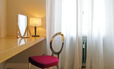 a chair sitting on a desk next to a mirror at Adamas Luxury Suite in Rome