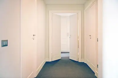 an empty hallway with white walls and two doors at Adamas Luxury Suite in Rome