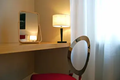 a mirror sitting on a shelf next to a red chair at Adamas Luxury Suite in Rome