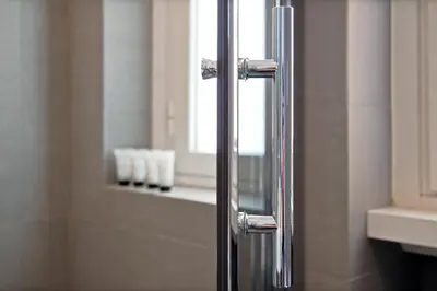 a glass shower door in a bathroom with a window at Adamas Luxury Suite in Rome