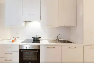 a white kitchen with a stove and a sink at Exclusive apartment a few steps from the Spanish Steps in Rome