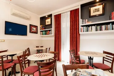 a restaurant with tables and chairs and a tv at Budget Rooms Des Arts in Rome