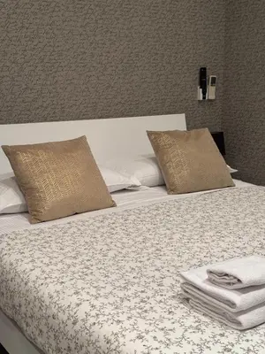a bed with white sheets and pillows in a room at Flaminio Holidays in Rome