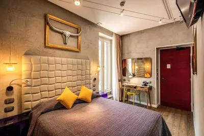 a bedroom with a bed with yellow pillows and a desk at Parlamento Boutique Hotel in Rome